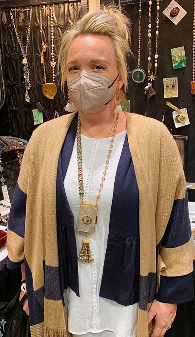 She is smiling under her mask…and loving her pearl pill box necklace!